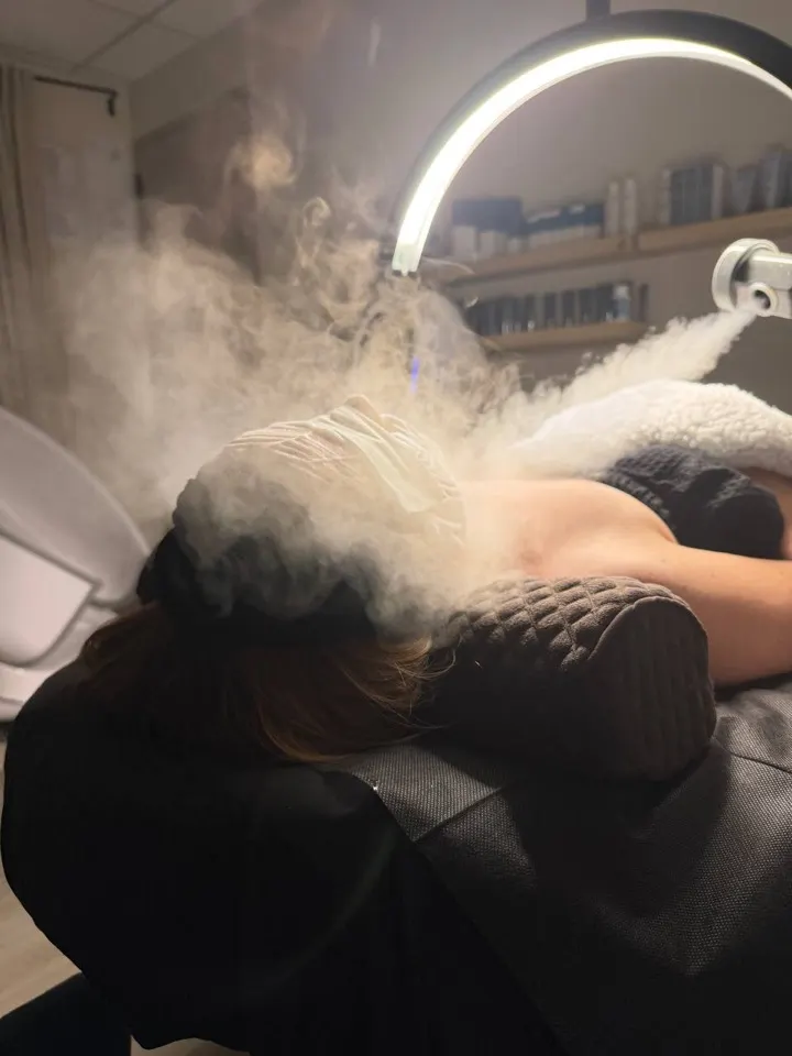 Client relaxing under facial steam at Revive Point Spa